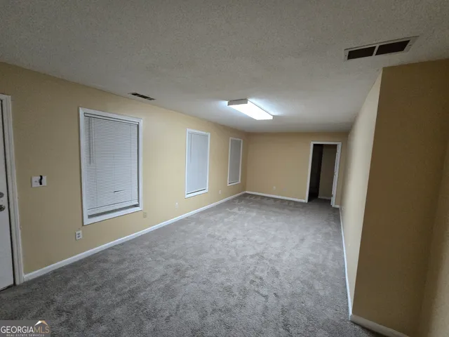 an empty room with a chandelier fan and closet