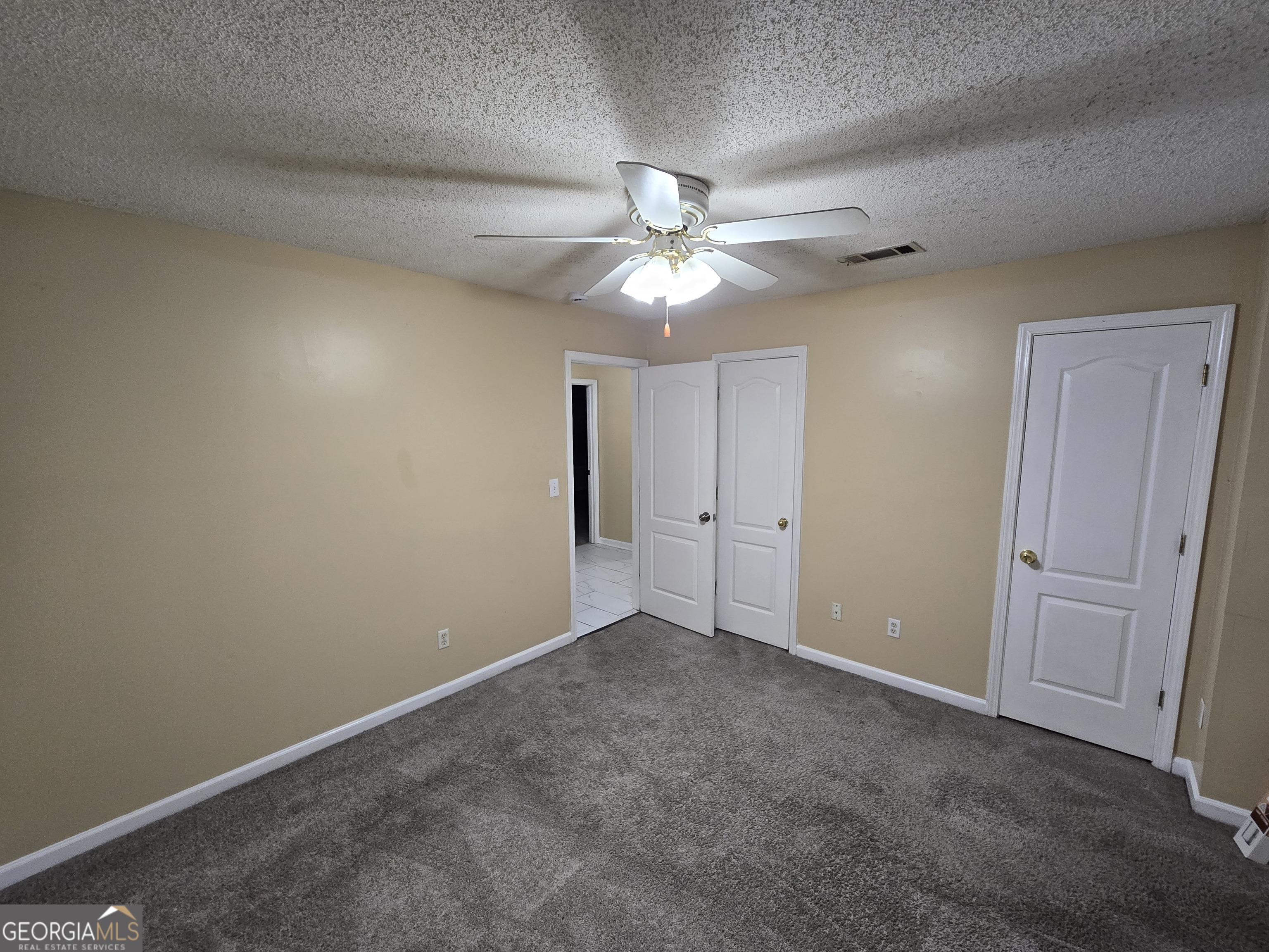 7486 Conkle Road Jonesboro, GA 30236 - Photo 12 of 13 an empty room with a chandelier fan and closet