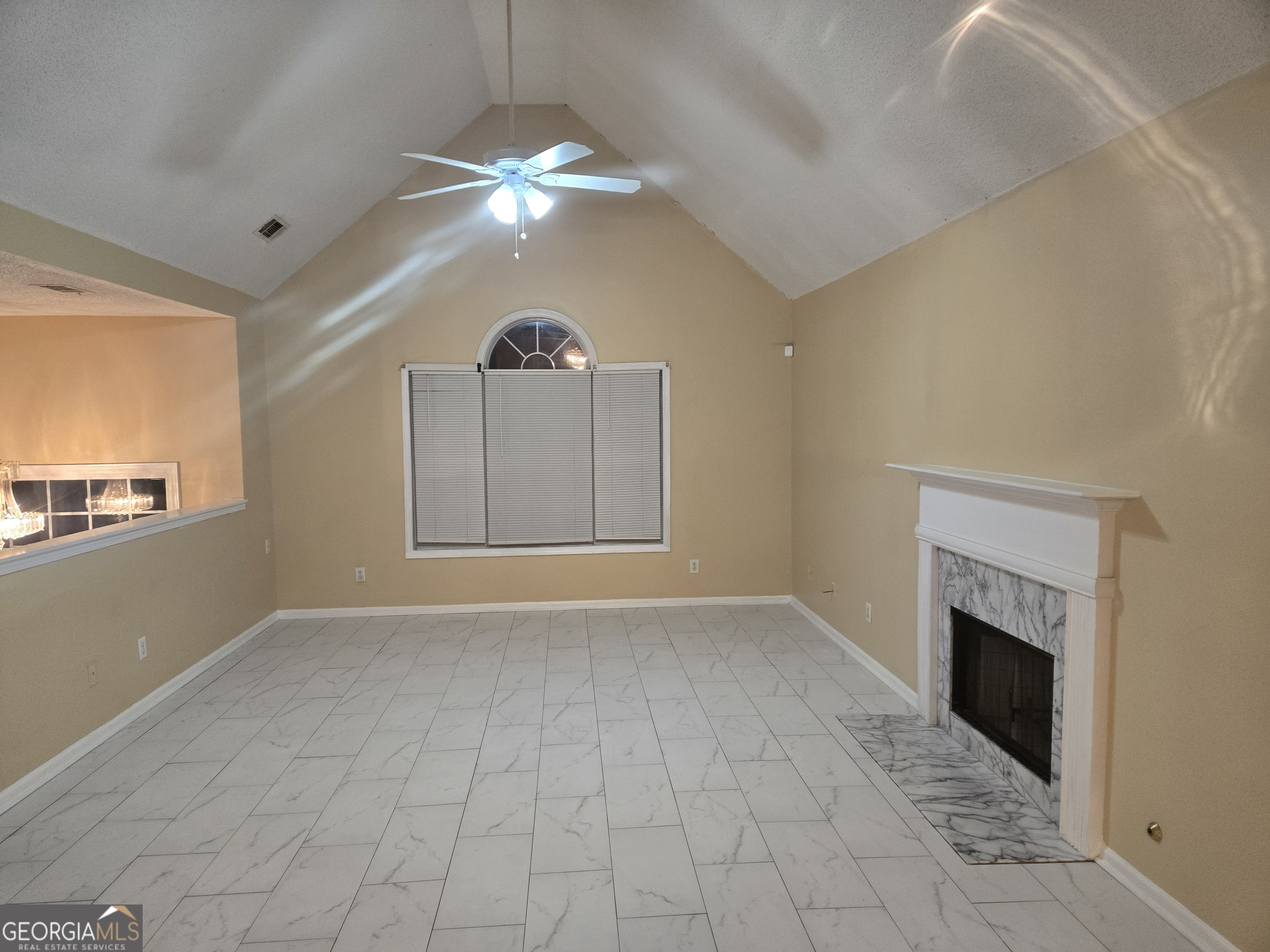 7486 Conkle Road Jonesboro, GA 30236 - Photo 2 of 13 an empty room with chandelier fan and fireplace