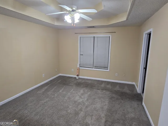 an empty room with closet and a chandelier fan