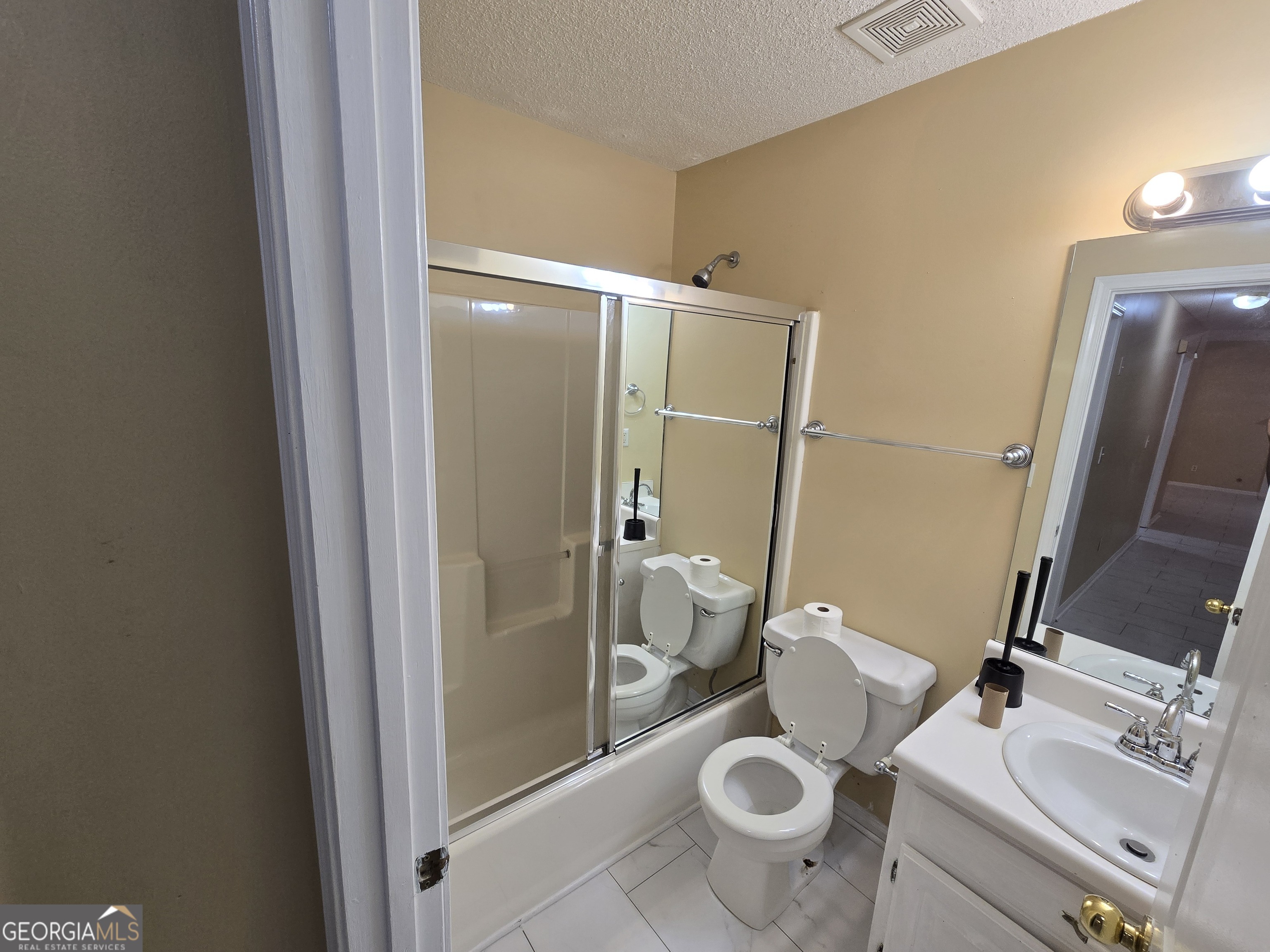 7486 Conkle Road Jonesboro, GA 30236 - Photo 8 of 13 a white toilet sitting next to a bathroom sink and a mirror