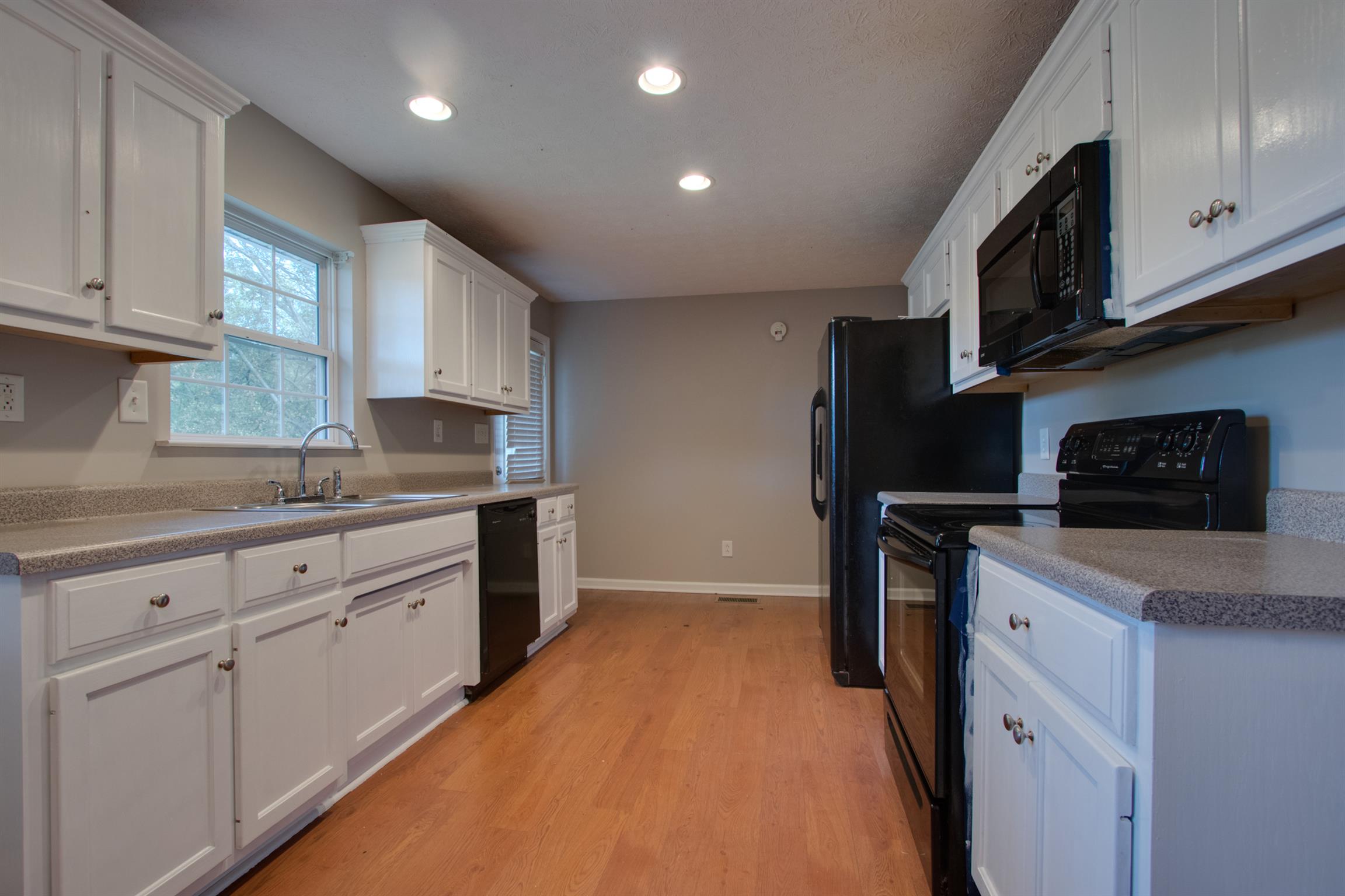201 High Street Alexandria, TN 37012 - Photo 11 of 23 a kitchen with granite countertop white cabinets and stainless steel appliances