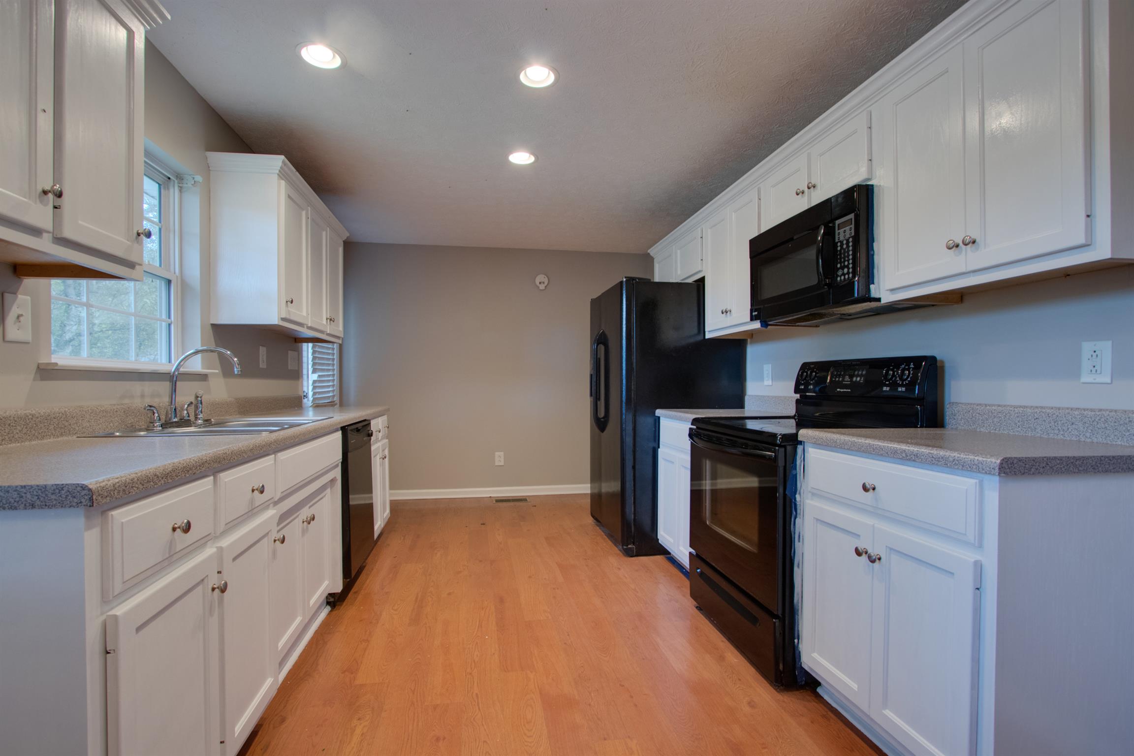 201 High Street Alexandria, TN 37012 - Photo 12 of 23 a kitchen with stainless steel appliances granite countertop a sink a stove a microwave and cabinets