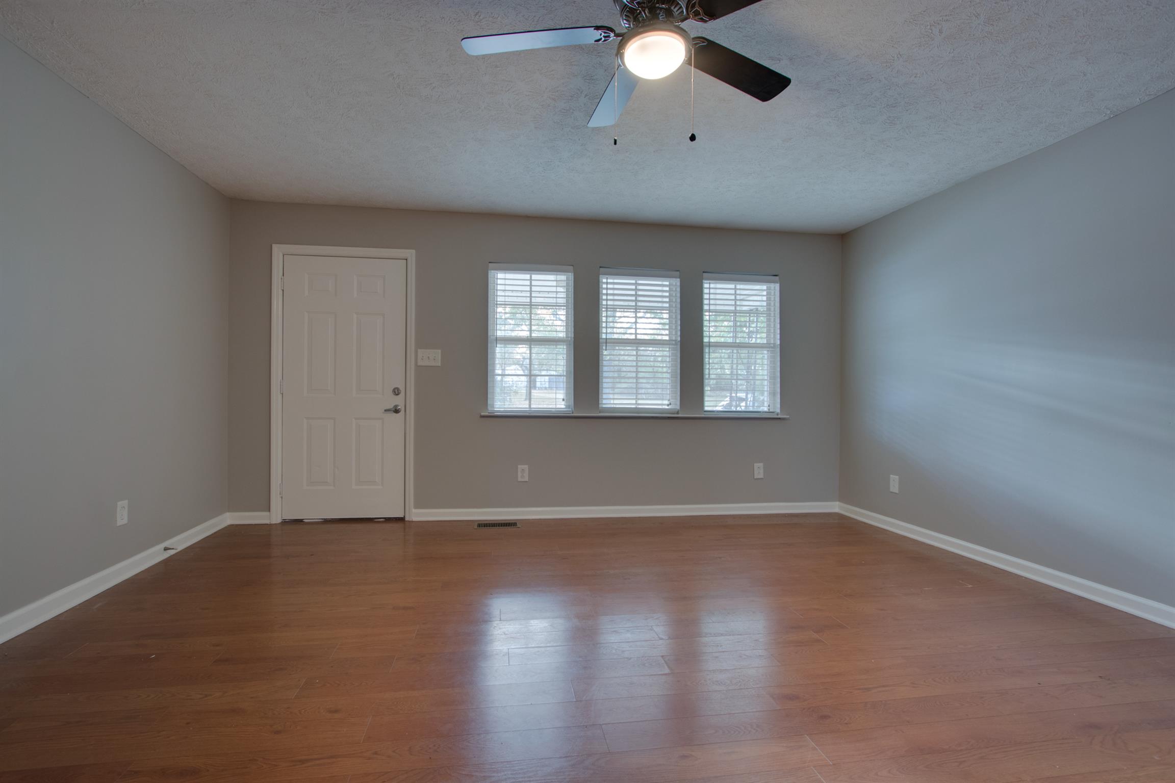 201 High Street Alexandria, TN 37012 - Photo 4 of 23 an empty room with wooden floor fan and windows