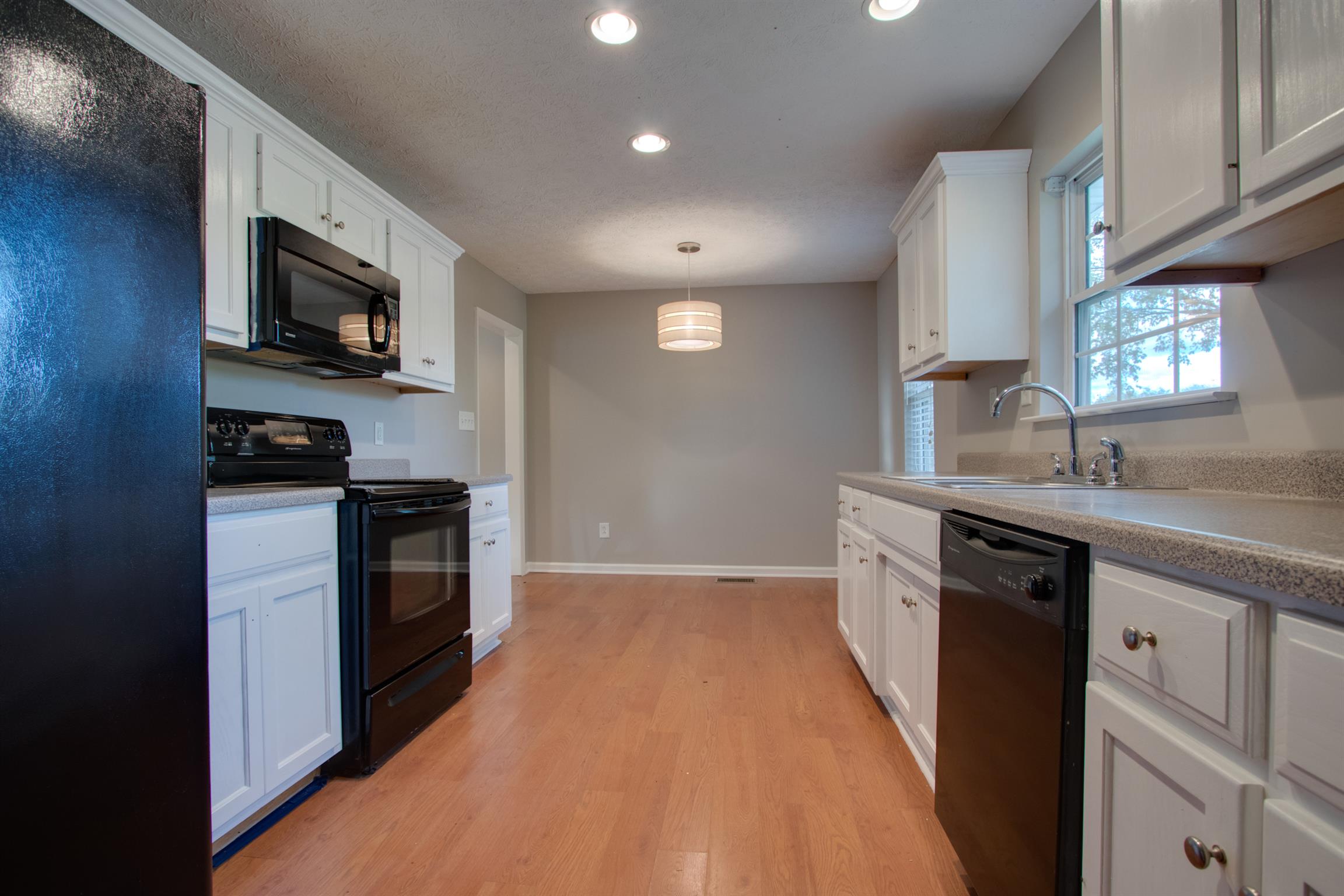 201 High Street Alexandria, TN 37012 - Photo 8 of 23 a kitchen with a sink stainless steel appliances and cabinets