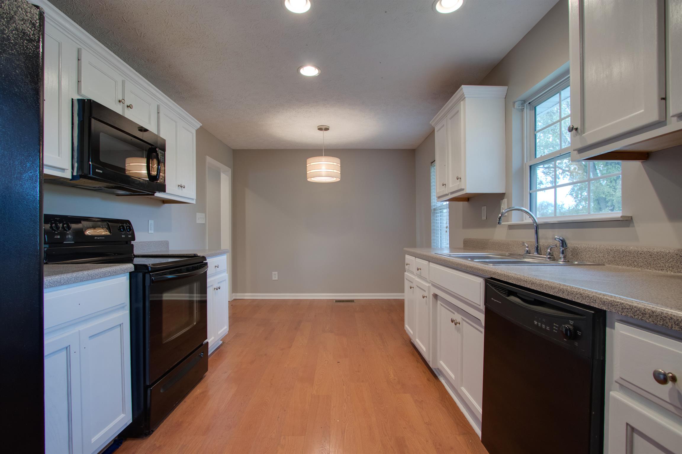 201 High Street Alexandria, TN 37012 - Photo 9 of 23 a kitchen with stainless steel appliances granite countertop a stove a sink and a microwave
