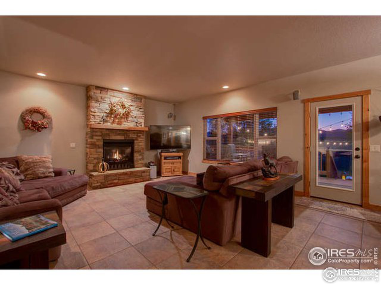 1441 Shelby Drive Berthoud, CO 80513 - Photo 14 of 40 a living room with furniture a fireplace and a flat screen tv
