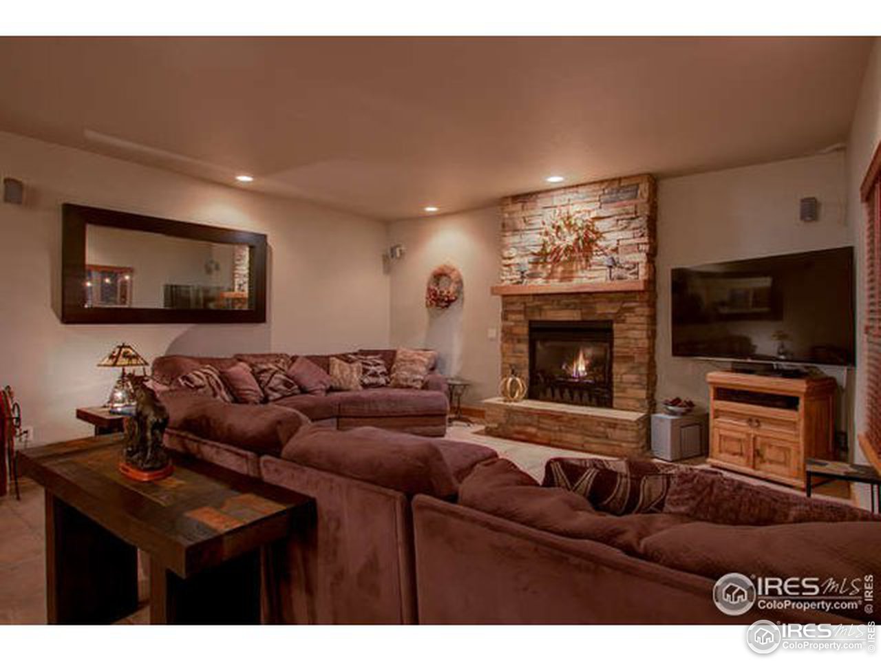 1441 Shelby Drive Berthoud, CO 80513 - Photo 15 of 40 a living room with furniture a flat screen tv and a fireplace