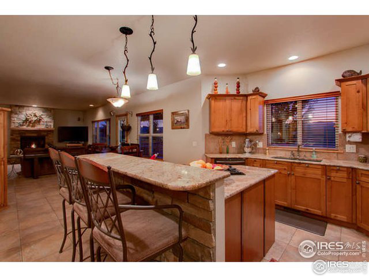 1441 Shelby Drive Berthoud, CO 80513 - Photo 21 of 40 a kitchen with stainless steel appliances kitchen island granite countertop a table chairs and a refrigerator