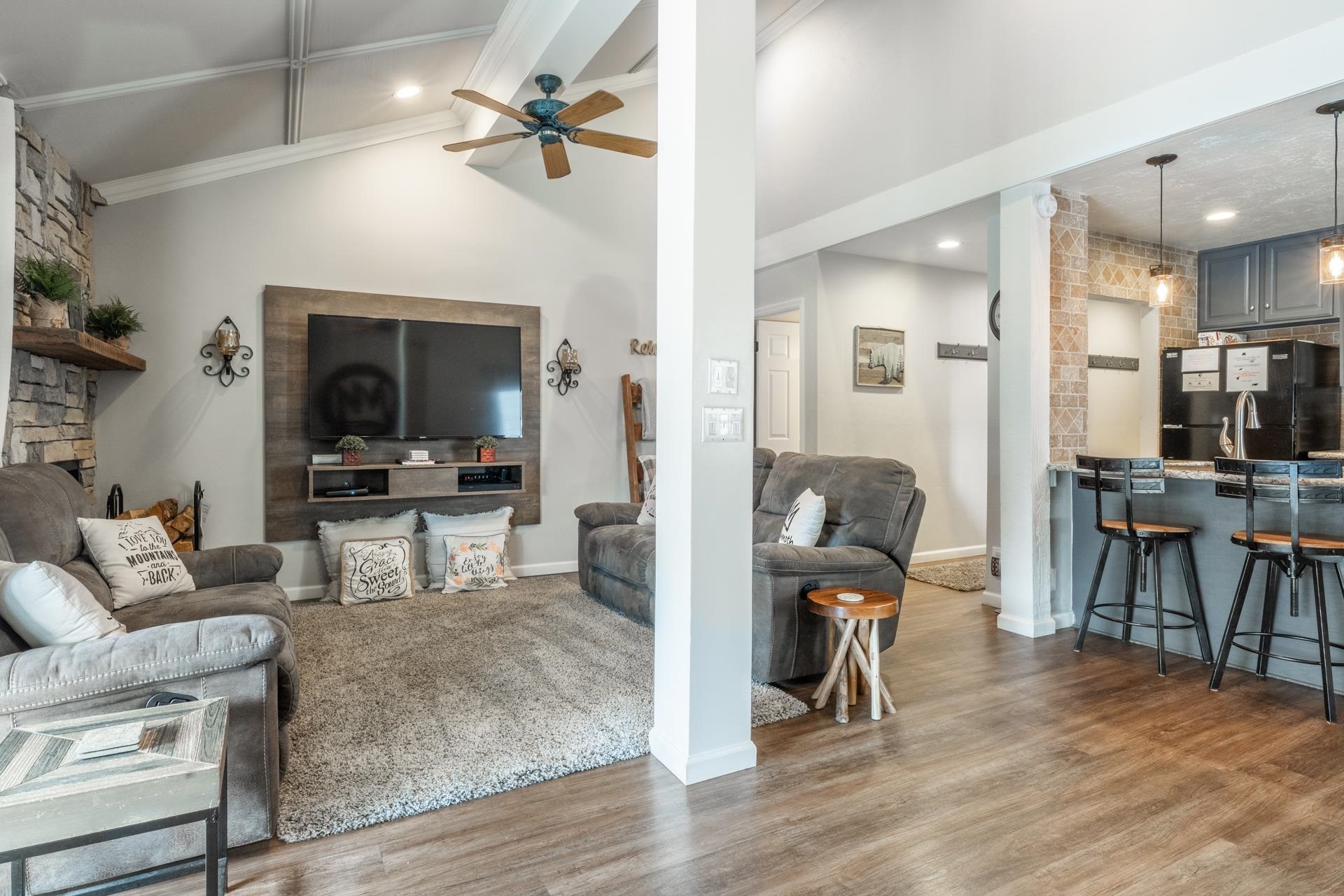 Living area featuring light wood-style flooring, ceiling fan, vaulted ceiling with beams, and recessed lighting