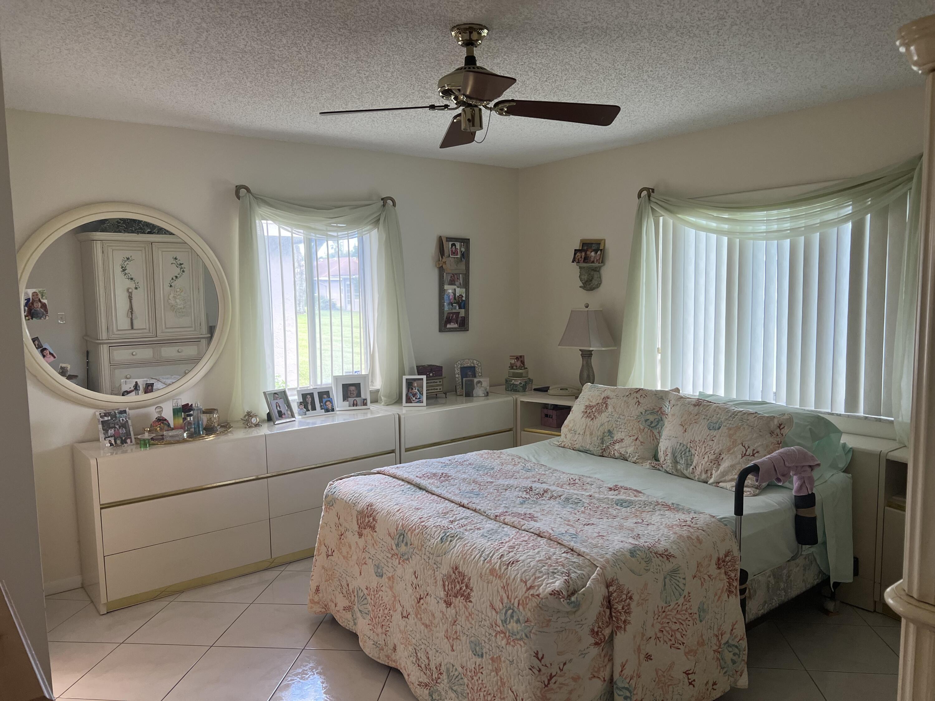 6877 Moonlit Drive Delray Beach, FL 33446 - Photo 13 of 45 a bedroom with a bed mirror and window