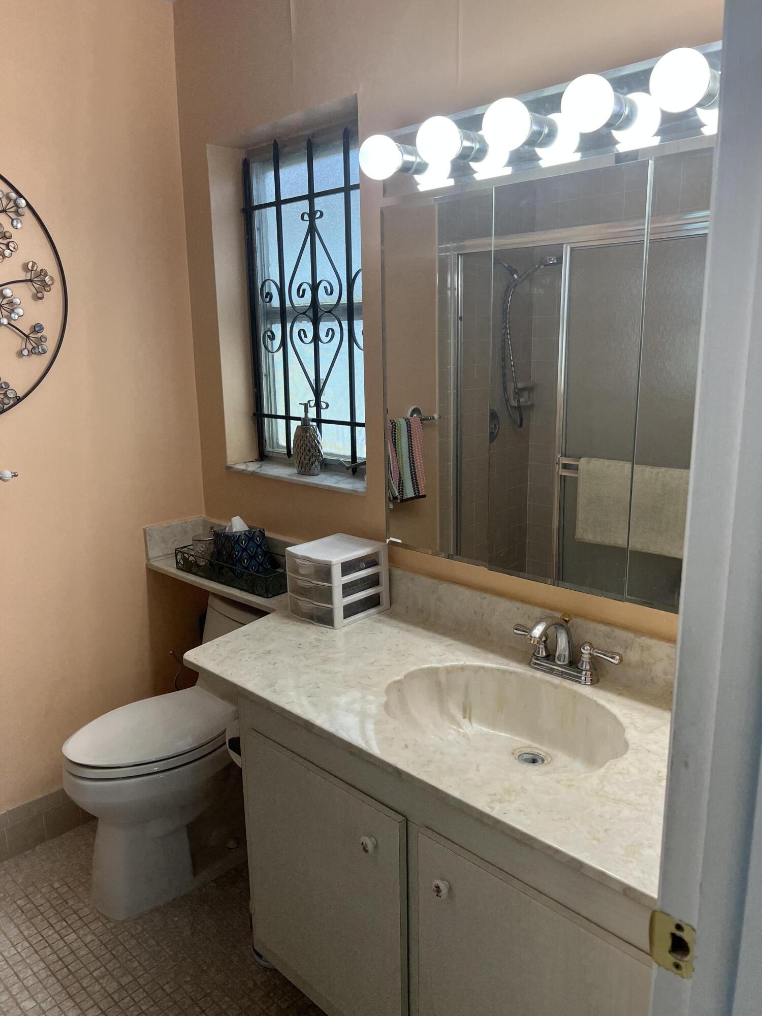 6877 Moonlit Drive Delray Beach, FL 33446 - Photo 14 of 45 a bathroom with a sink a toilet and a mirror