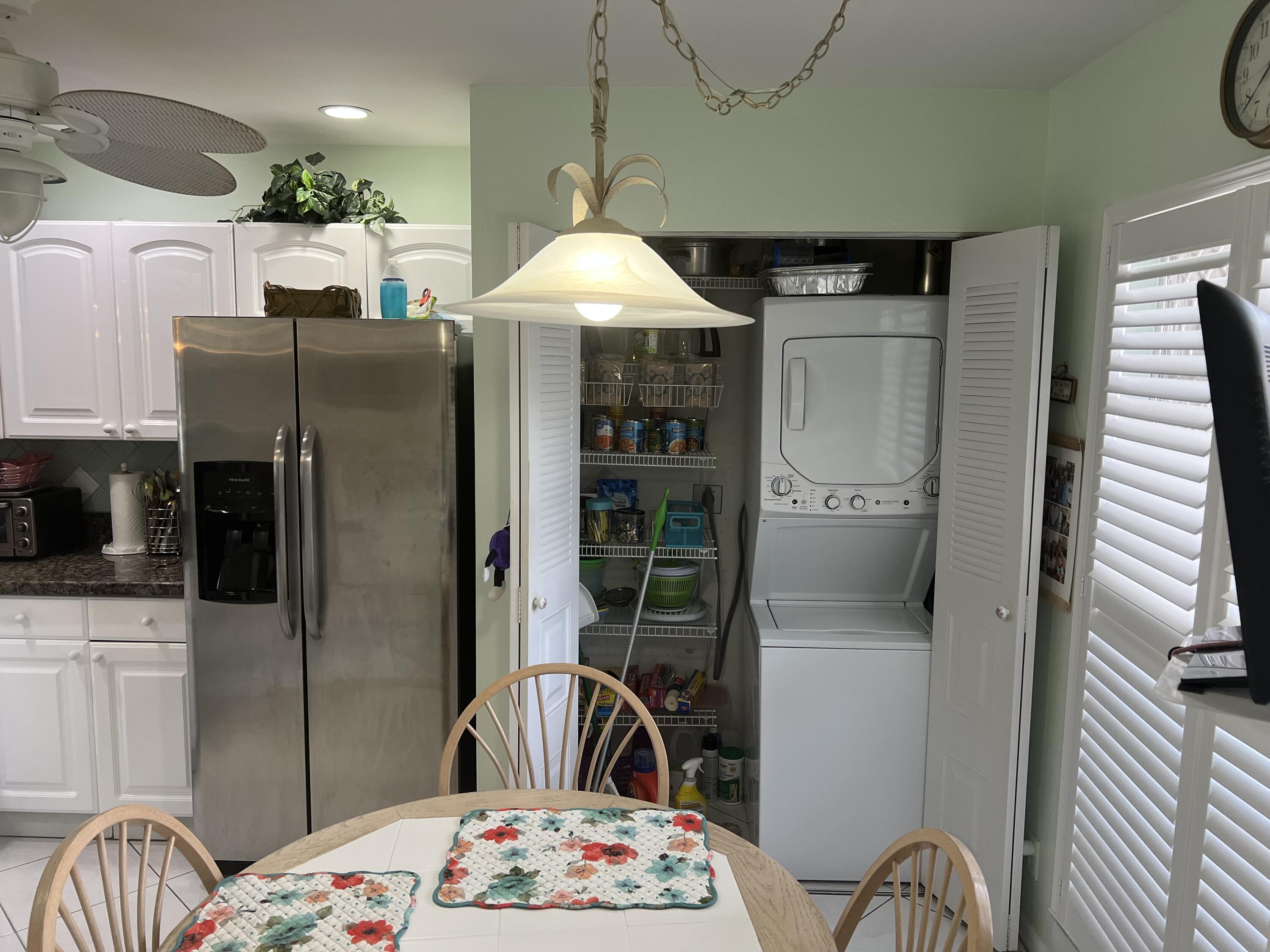 6877 Moonlit Drive Delray Beach, FL 33446 - Photo 16 of 45 a kitchen with a refrigerator and a table