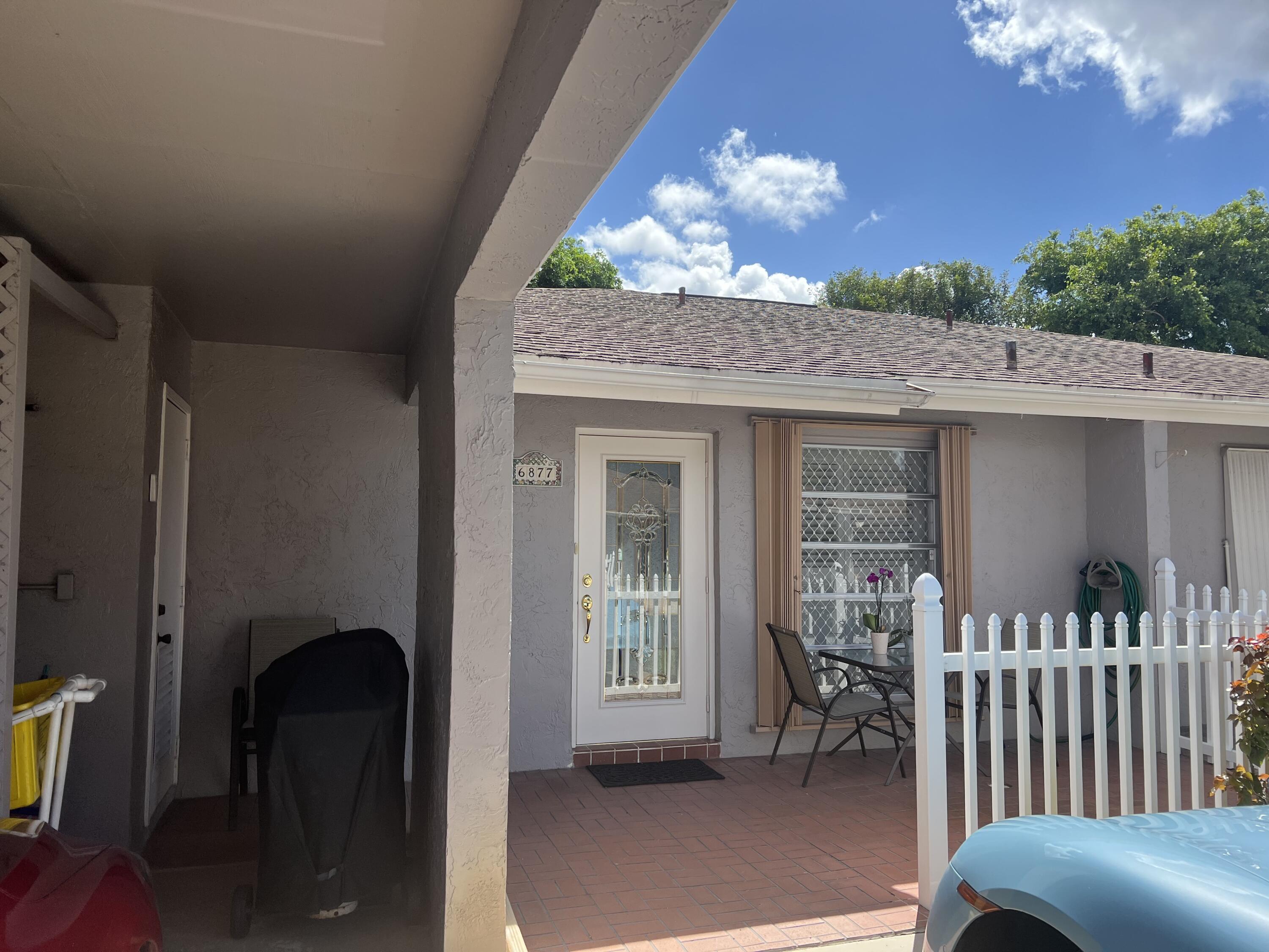 6877 Moonlit Drive Delray Beach, FL 33446 - Photo 19 of 45 a front view of a house with a porch