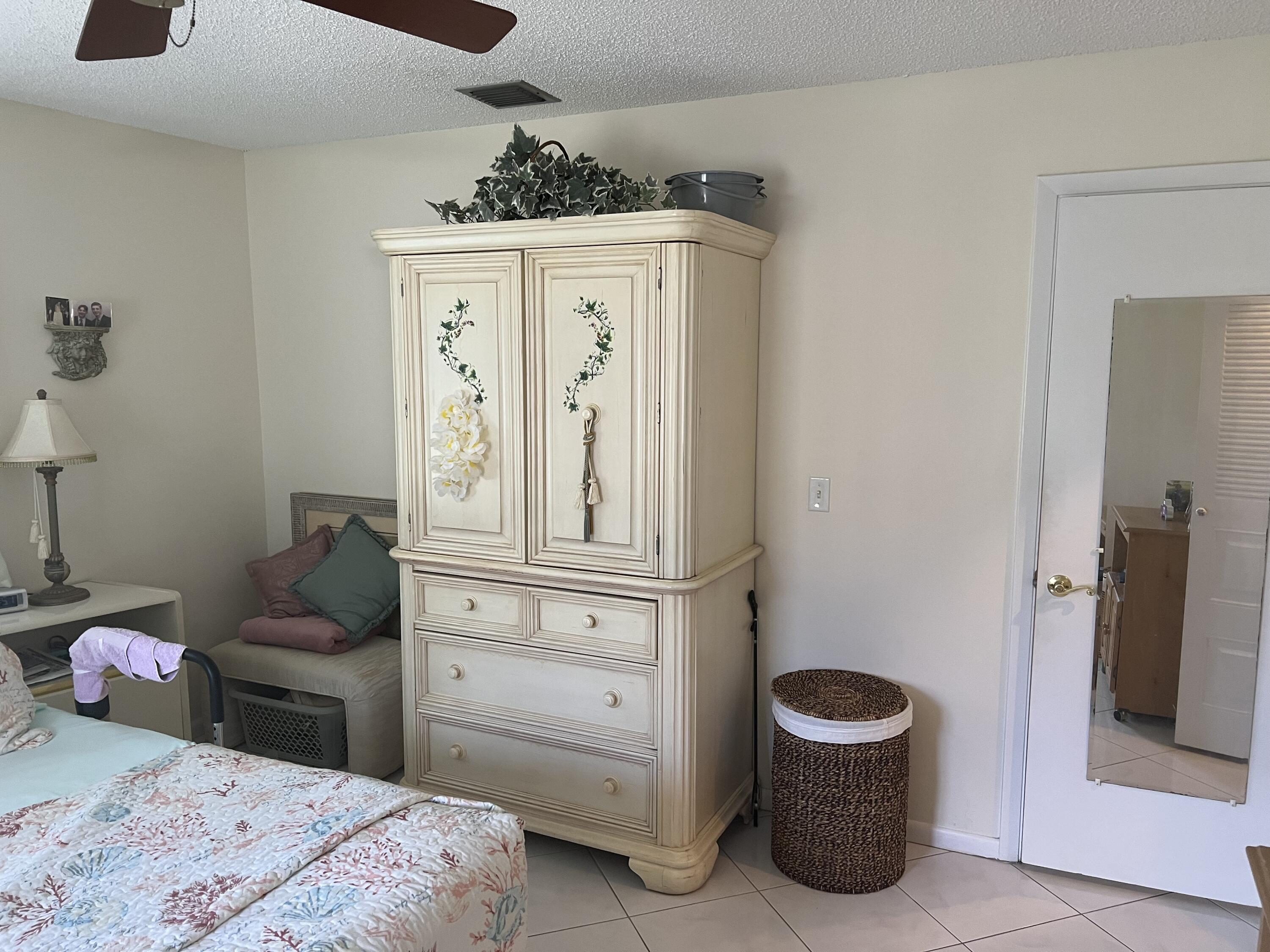 6877 Moonlit Drive Delray Beach, FL 33446 - Photo 23 of 45 a bedroom with a bed and cabinets