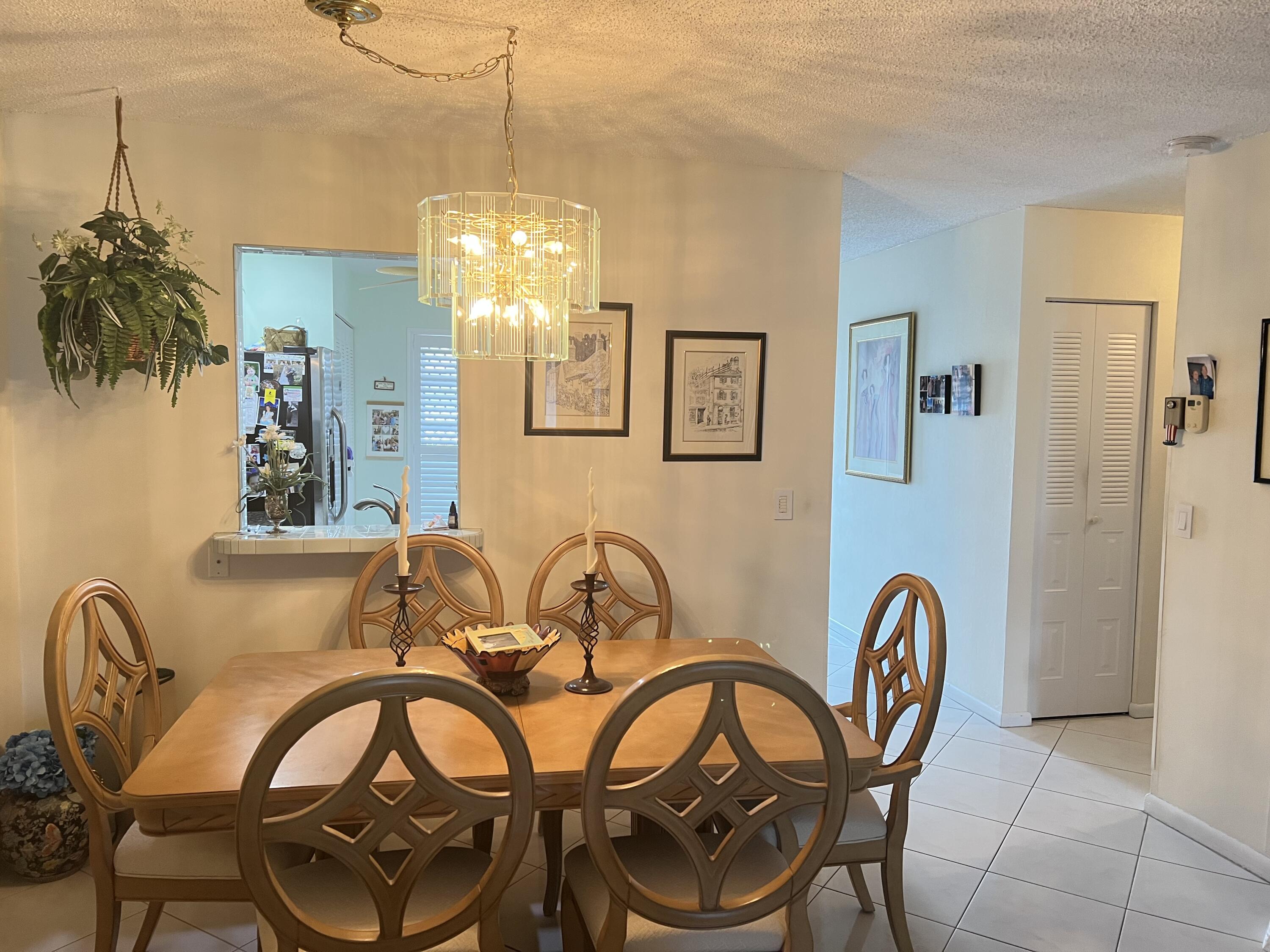6877 Moonlit Drive Delray Beach, FL 33446 - Photo 25 of 45 a view of a dining room with furniture and chandelier