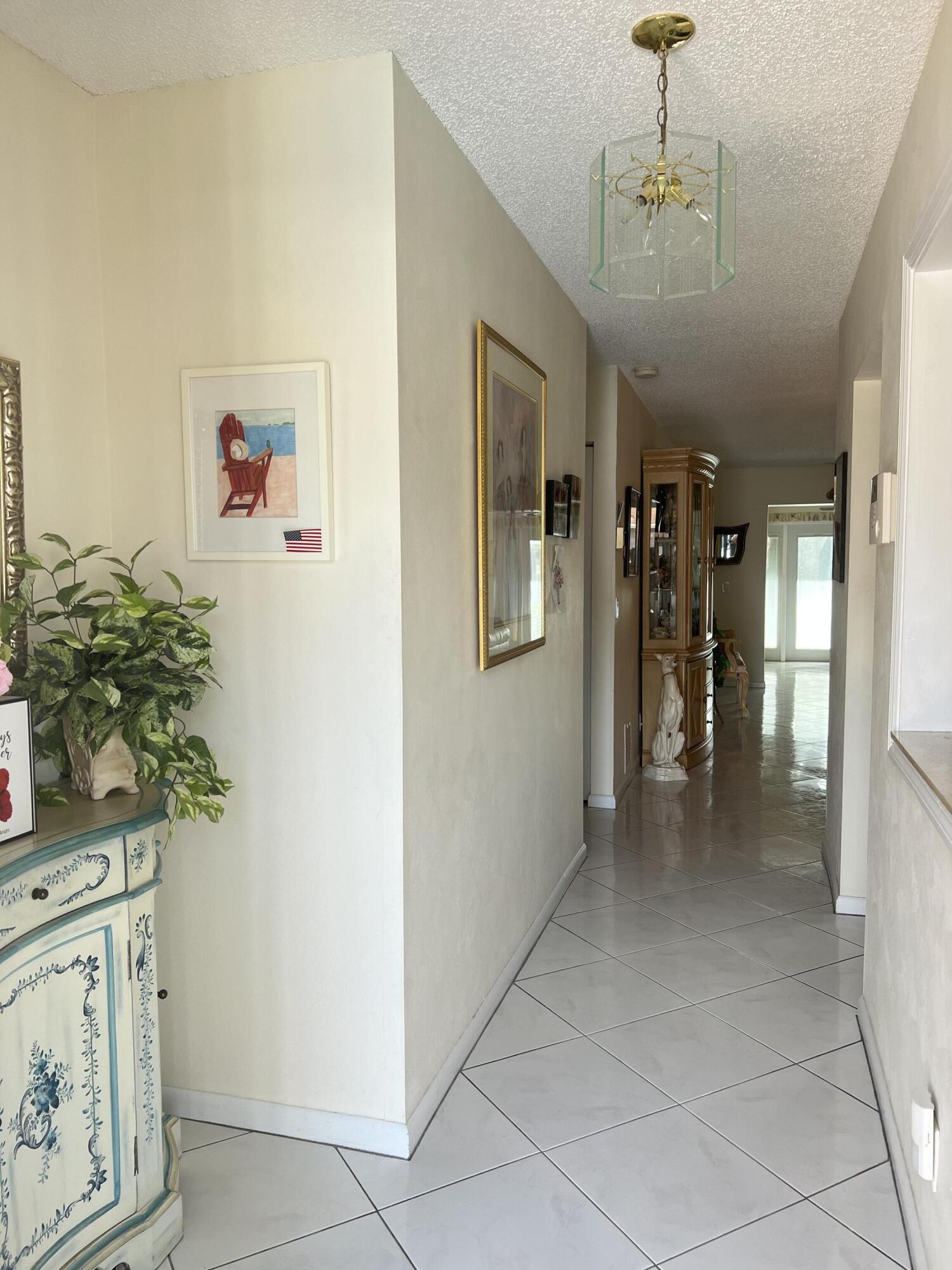 6877 Moonlit Drive Delray Beach, FL 33446 - Photo 28 of 45 a view of a hallway with entryway and chandelier