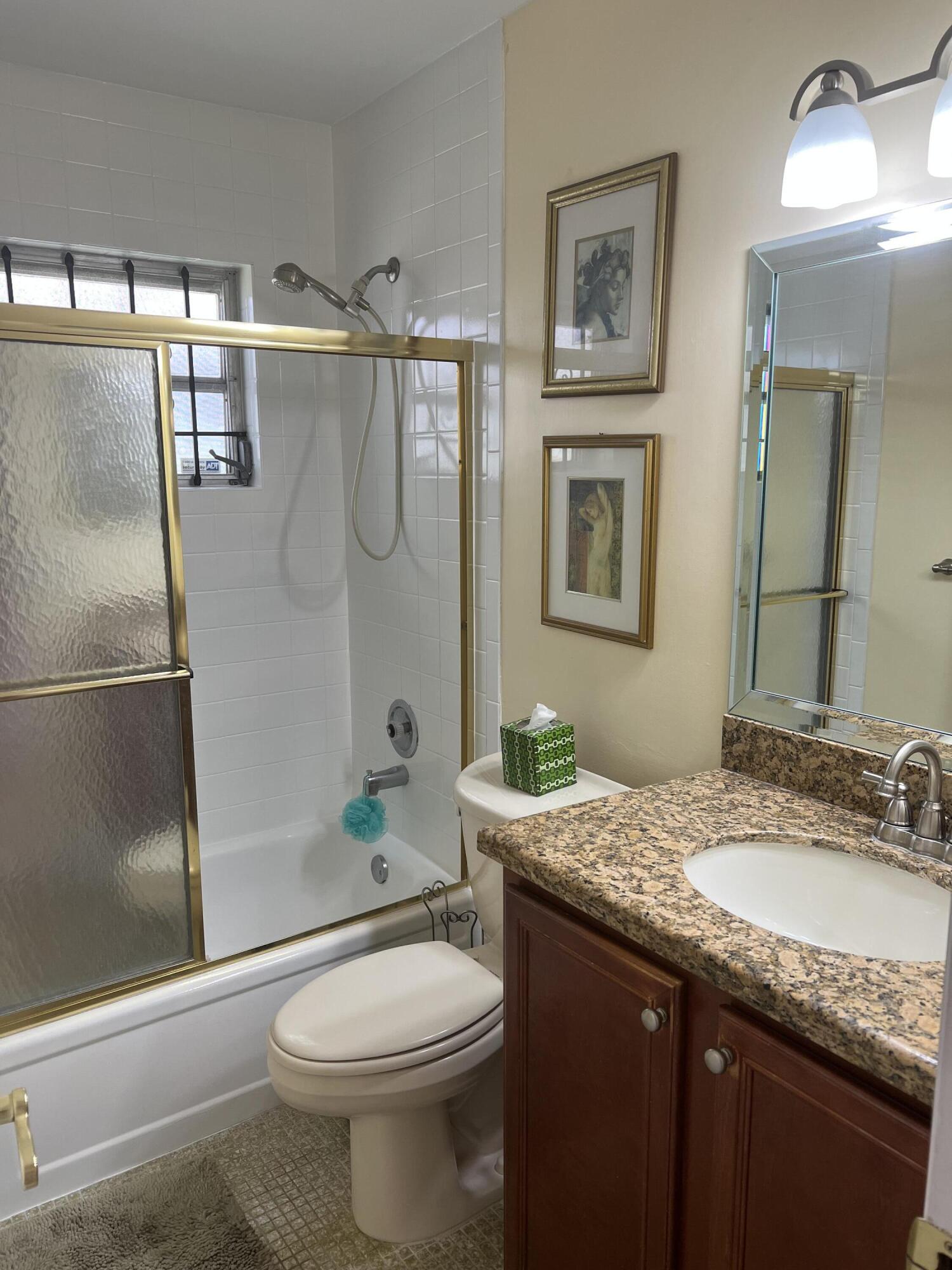 6877 Moonlit Drive Delray Beach, FL 33446 - Photo 10 of 45 a bathroom with a granite countertop toilet sink and shower