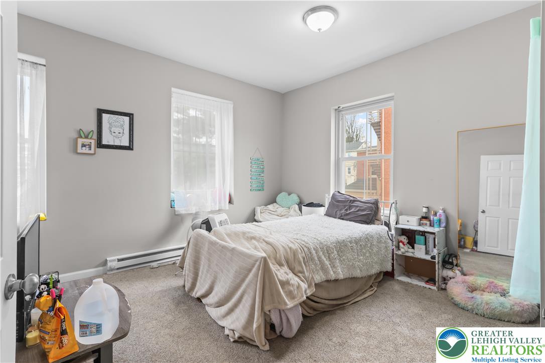 12 South Front Street Coplay, PA 18037 - Photo 13 of 41 This inviting bedroom features ample natural light and plush carpeting, creating a comfortable living space.