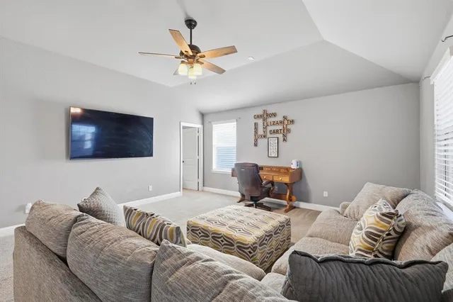 a living room with furniture and a ceiling fan