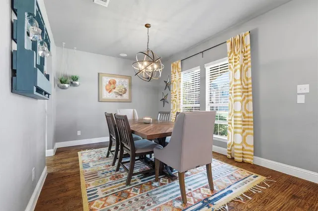 a view of a dining room with furniture wooden floor and a chandelier