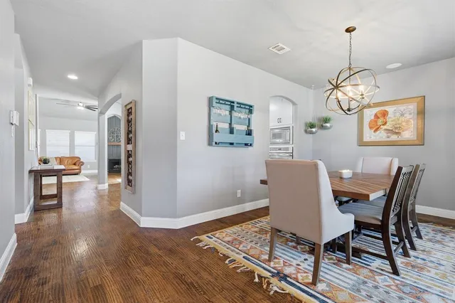 a kitchen with stainless steel appliances granite countertop a sink a stove a refrigerator and island with wooden floor