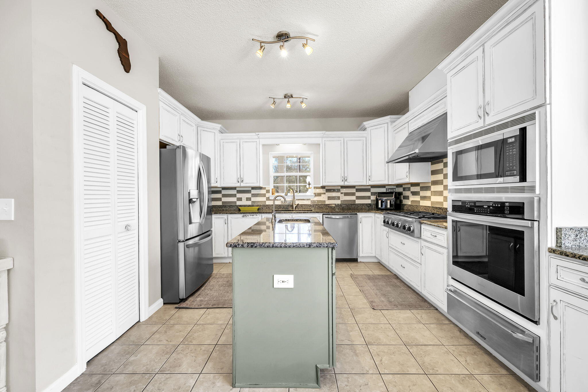4398 Wilkerson Bluff Road Holt, FL 32564 - Photo 25 of 110 a kitchen with stainless steel appliances granite countertop a refrigerator a stove a sink and cabinets