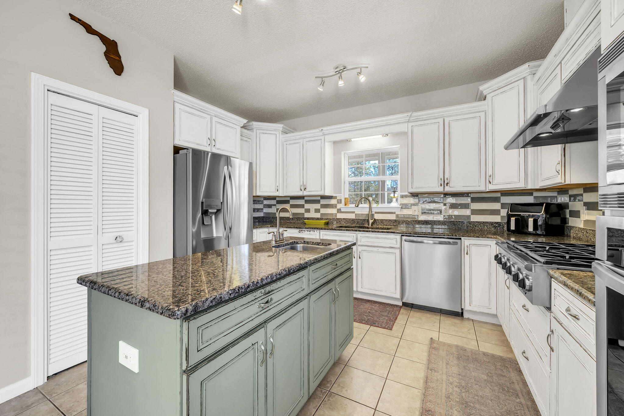 4398 Wilkerson Bluff Road Holt, FL 32564 - Photo 26 of 110 a kitchen with stainless steel appliances granite countertop a stove refrigerator sink and microwave