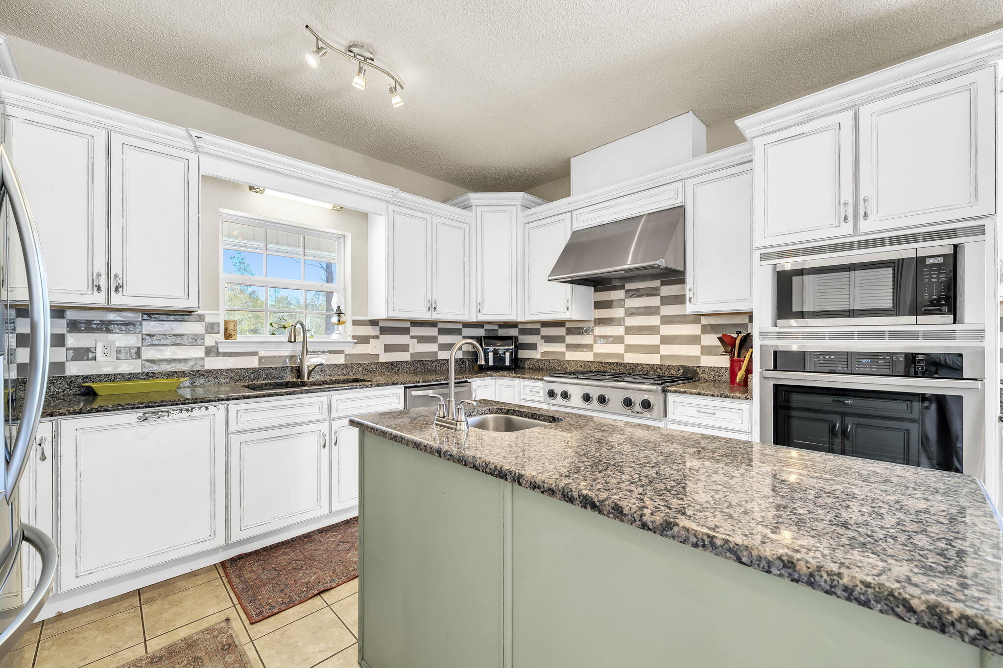 4398 Wilkerson Bluff Road Holt, FL 32564 - Photo 27 of 110 a kitchen with stainless steel appliances granite countertop a stove sink and cabinets