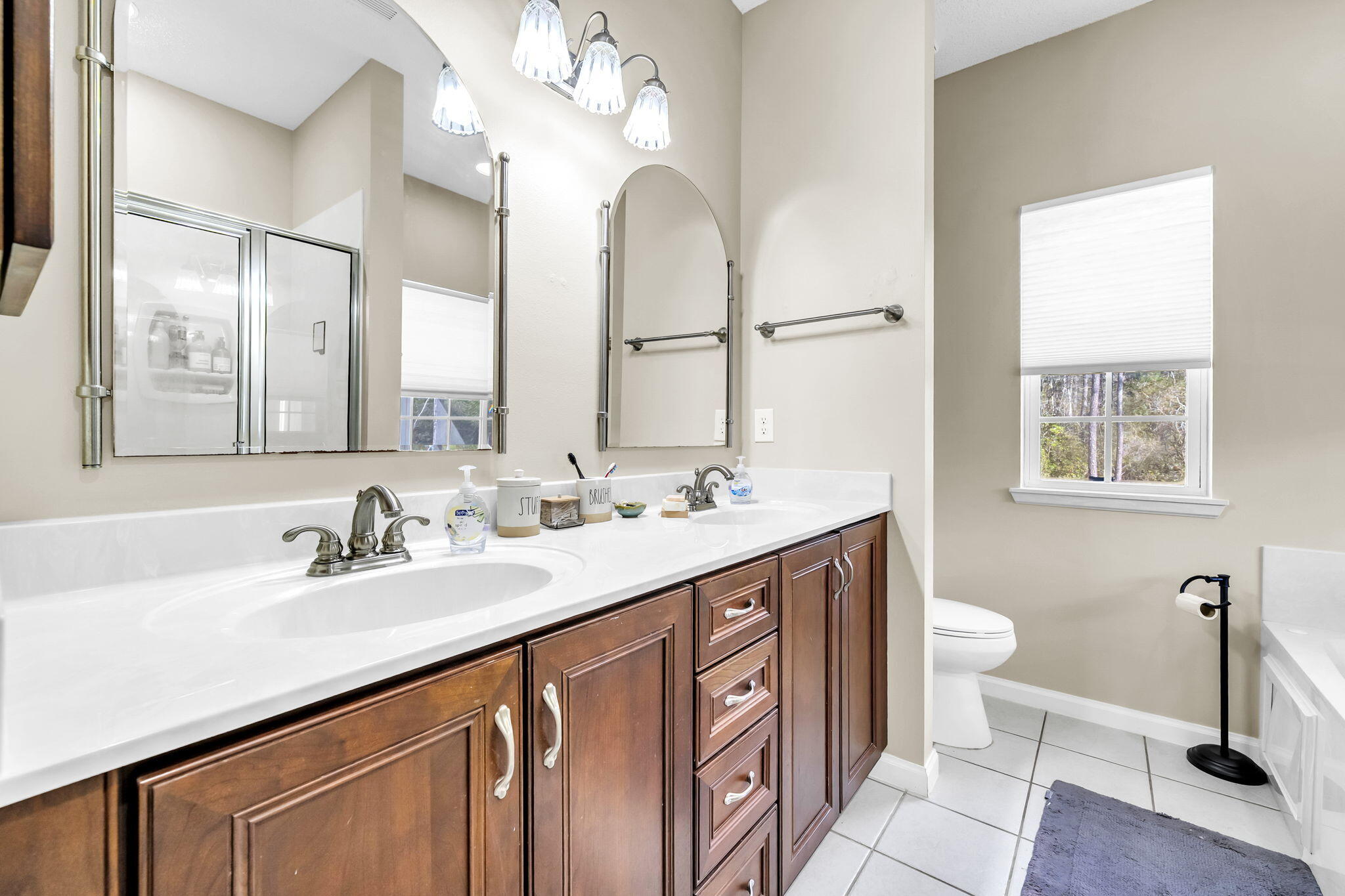 4398 Wilkerson Bluff Road Holt, FL 32564 - Photo 37 of 110 a bathroom with a double vanity sink a toilet and a mirror