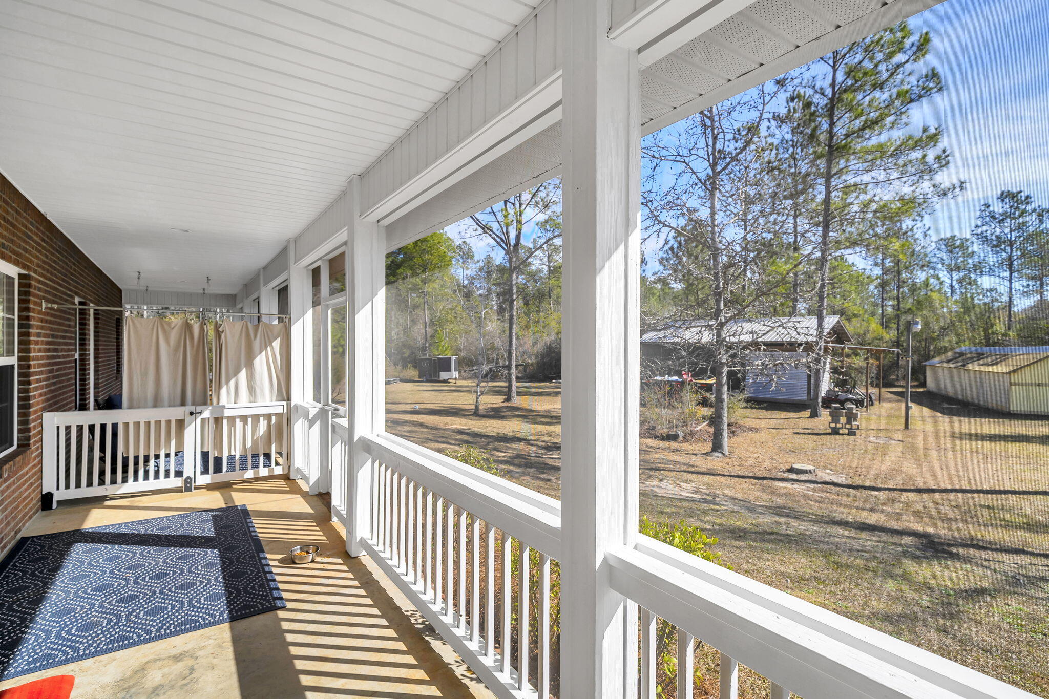 4398 Wilkerson Bluff Road Holt, FL 32564 - Photo 45 of 110 a view of a porch with wooden floor and fence