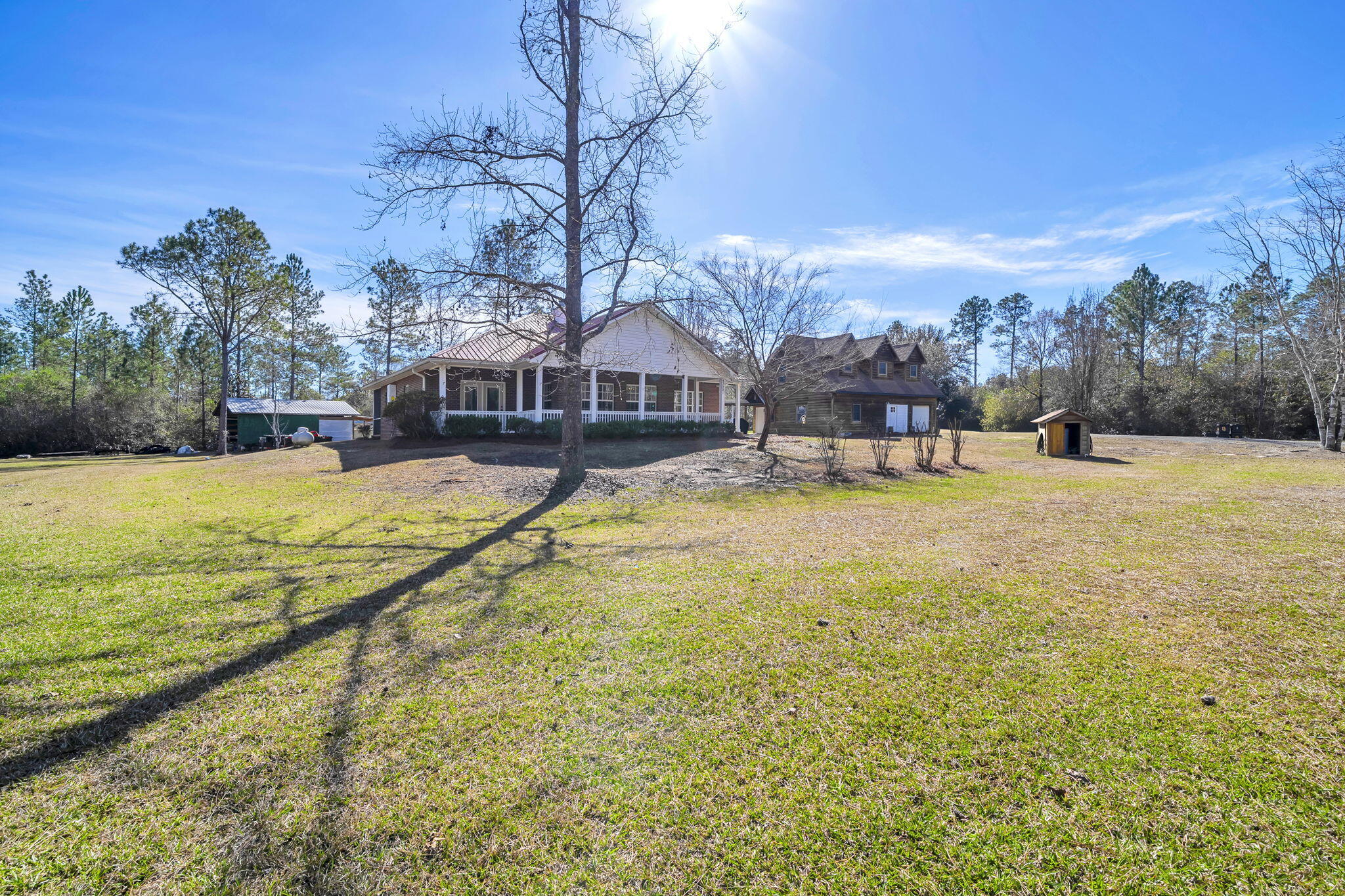 4398 Wilkerson Bluff Road Holt, FL 32564 - Photo 73 of 110 a view of a swimming pool with lawn chairs and large trees