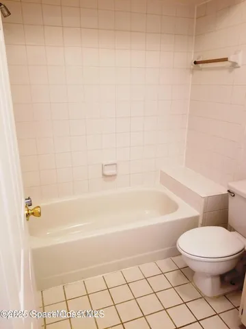 a bathroom with a toilet and a bath tub