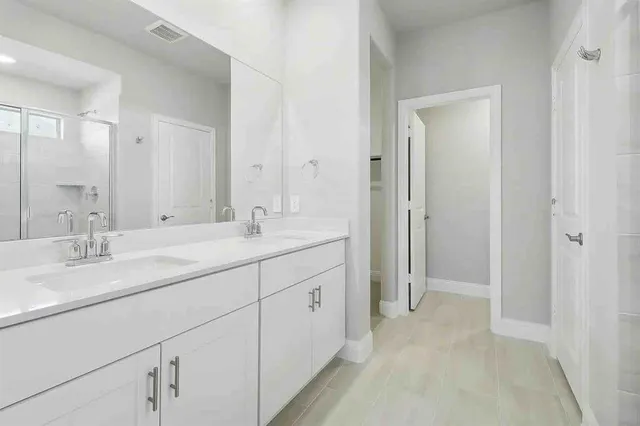 a bathroom with double vanity sink and a mirror