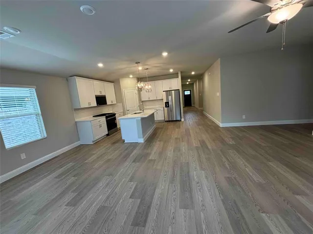 a view of a kitchen with wooden floor and a window