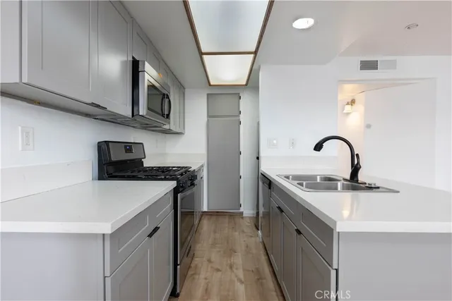a kitchen with stainless steel appliances granite countertop a sink and a stove top oven