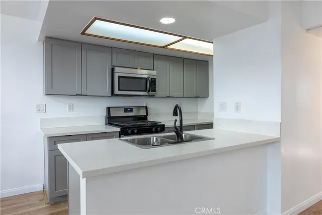 a kitchen with a sink a microwave and cabinets