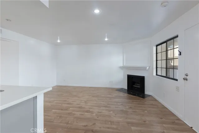 a view of empty room with wooden floor and fireplace