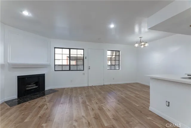 an empty room with windows and fireplace
