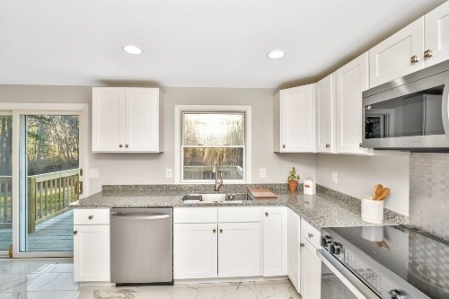 903 Main Street Bolton, MA 01740 - Photo 4 of 39 a kitchen with granite countertop white cabinets and white appliances