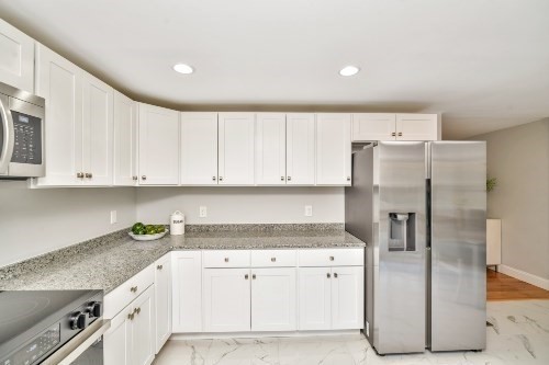 903 Main Street Bolton, MA 01740 - Photo 6 of 39 a kitchen with granite countertop white cabinets and refrigerator