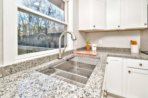 903 Main Street Bolton, MA 01740 - Photo 8 of 39 a kitchen with granite countertop a stove and white cabinets