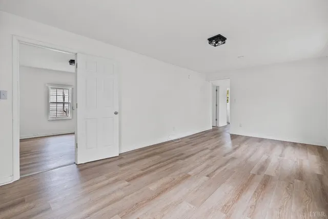 a view of an empty room with wooden floor