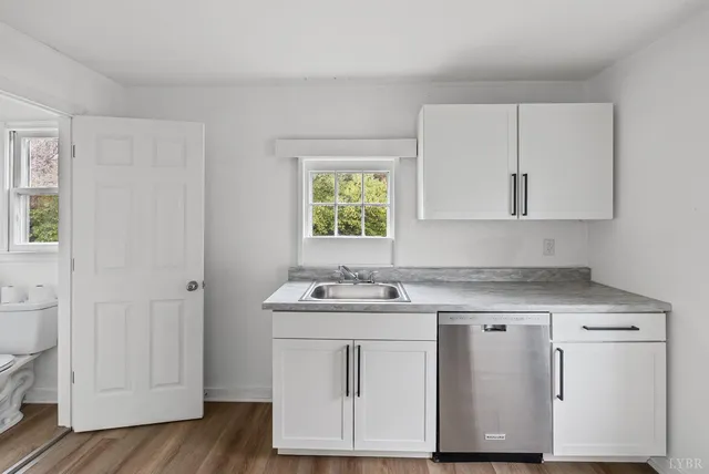a kitchen with white cabinets appliances and sink