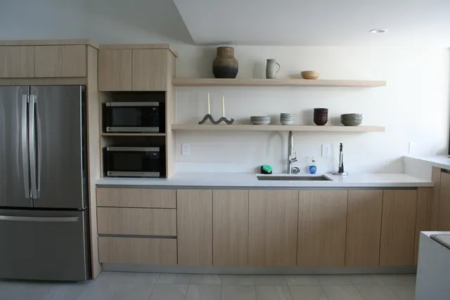 a kitchen with white cabinets and refrigerator
