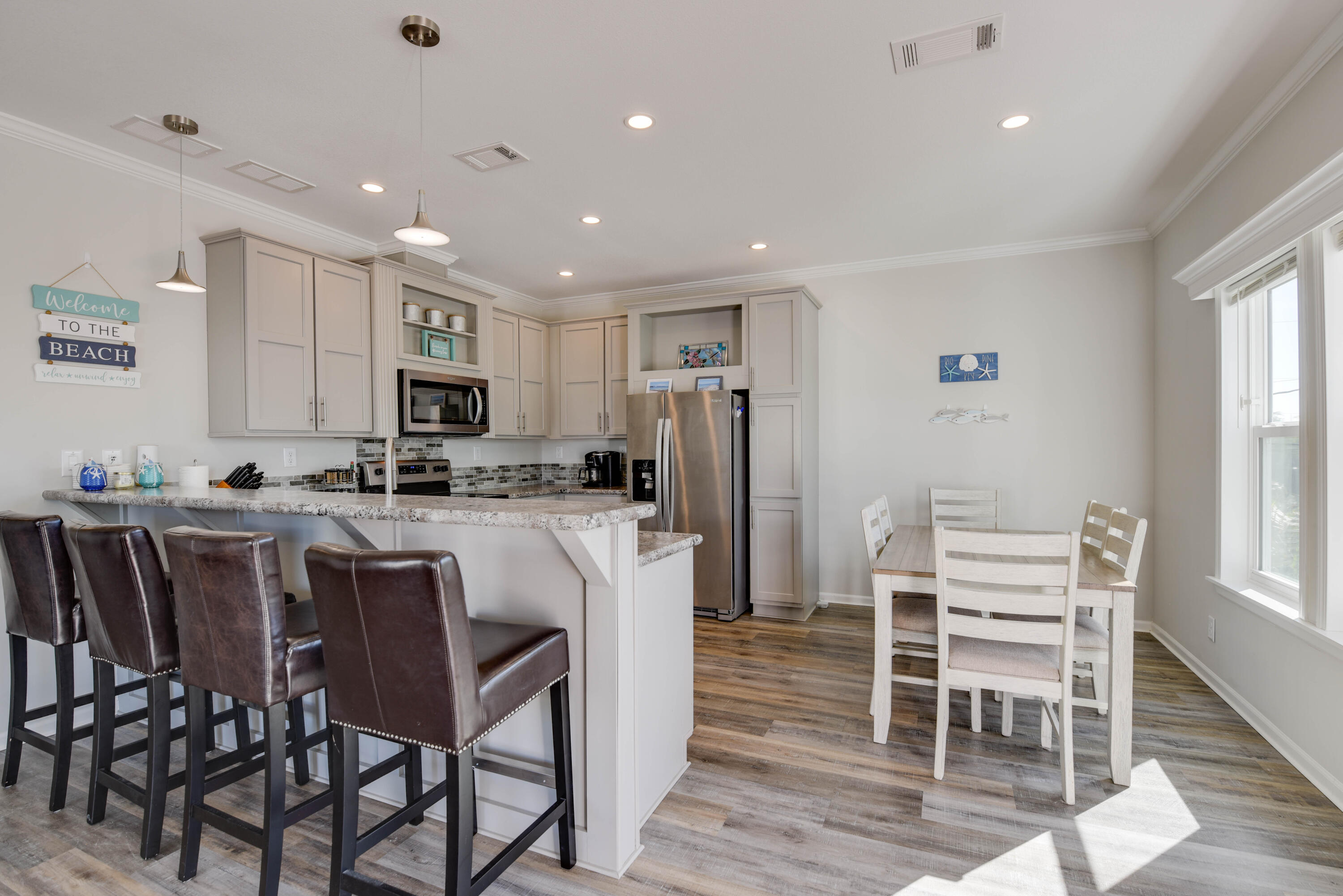 31343 Ave I Big Pine Key, FL 33043 - Photo 4 of 29 a kitchen with stainless steel appliances kitchen island granite countertop a table chairs and a refrigerator