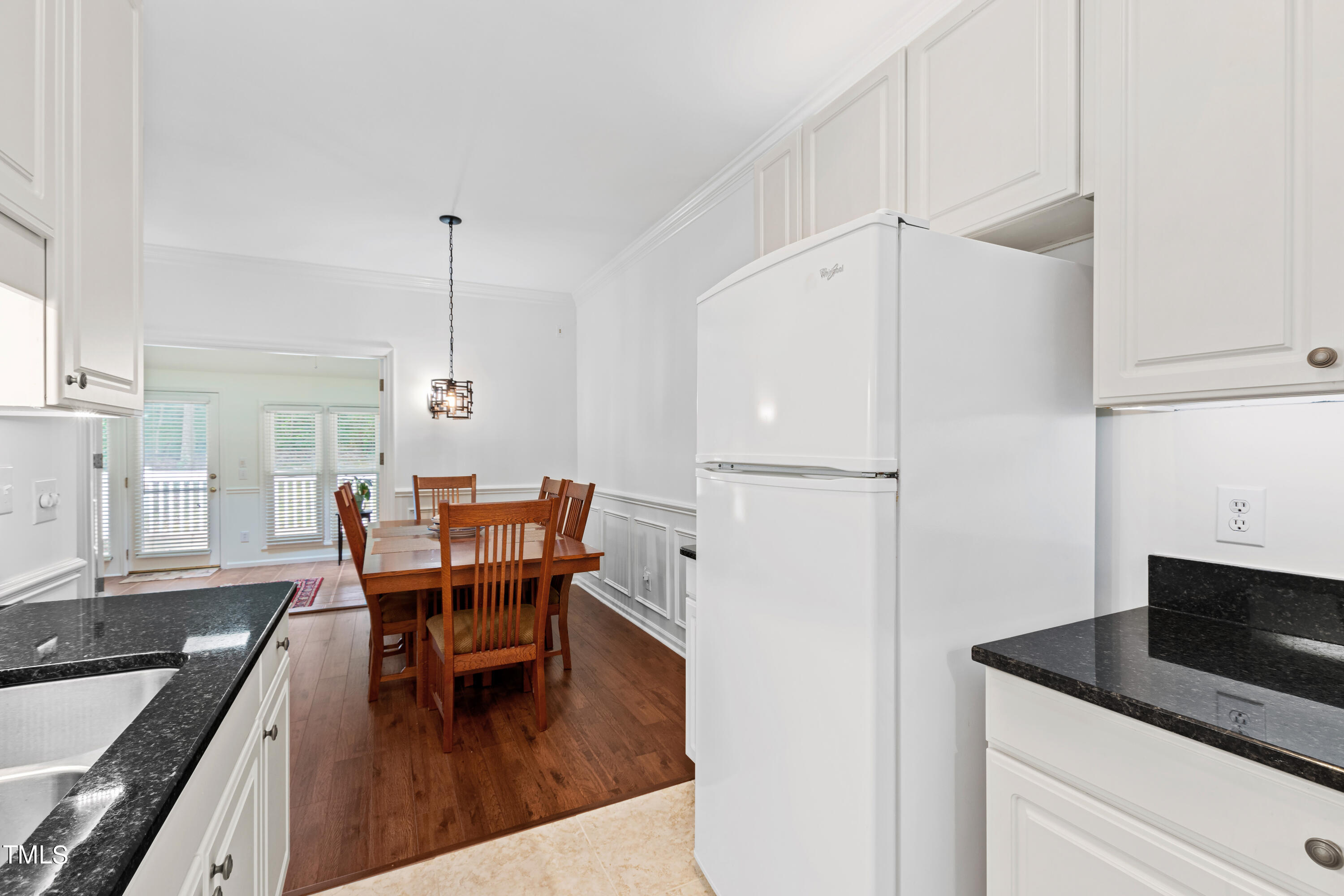 3834 Carnegie Lane Raleigh, NC 27612 - Photo 11 of 38 a kitchen with a table chairs and a refrigerator