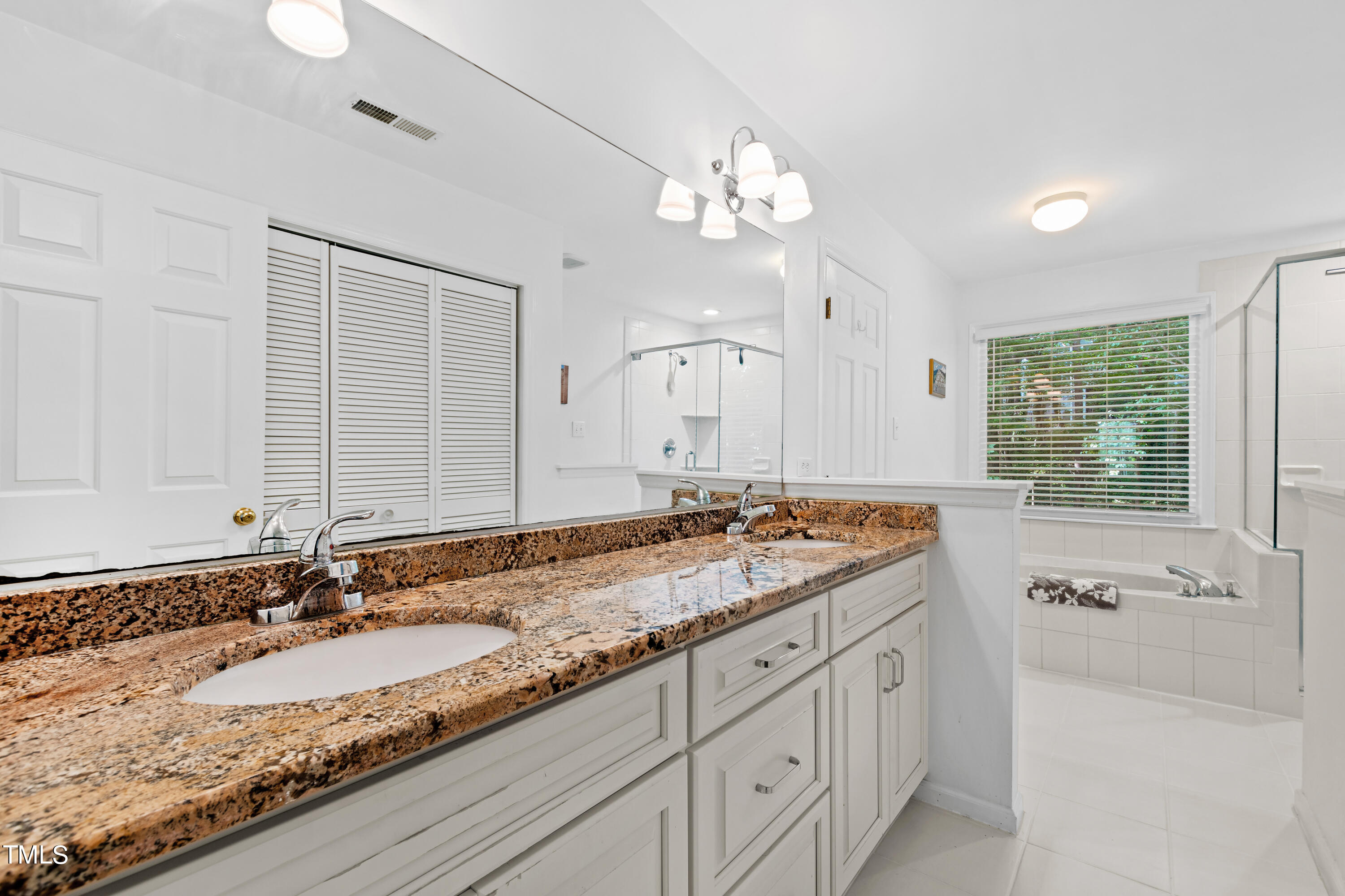 3834 Carnegie Lane Raleigh, NC 27612 - Photo 32 of 38 a bathroom with a granite countertop sink and a large mirror