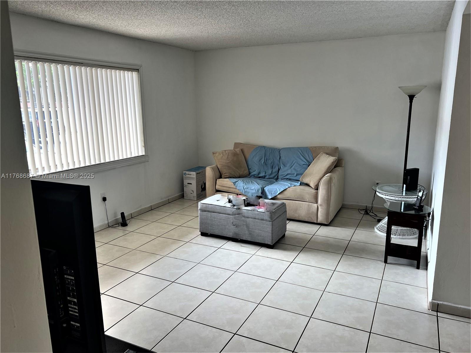 8401 Southwest 107th Avenue, Unit 121E Miami, FL 33173 - Photo 5 of 19 a living room with furniture and a window