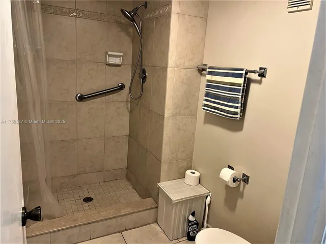 a bathroom with a shower a toilet and sink